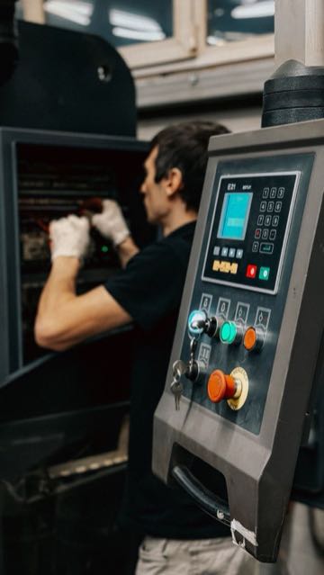 Technician inspecting electronic components at a workstation